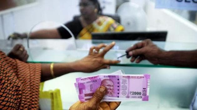 File photo taken on November 17, 2016 shows an Indian woman holding Rs 2000 notes as she has her finger marked with indelible ink after exchanging demonetised Rs 500 and Rs 1000 notes at a bank in Chennai.(AFP)