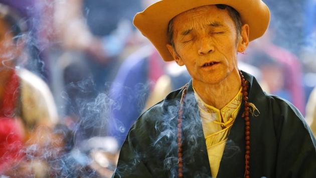 Smoke rise from the burning incense as a Tibetan man in traditional attire offers prayers . (Navesh Chitrakar / REUTERS) Smoke rise from the burning incense as a Tibetan man in traditional attire offers prayers . (Navesh Chitrakar / REUTERS)