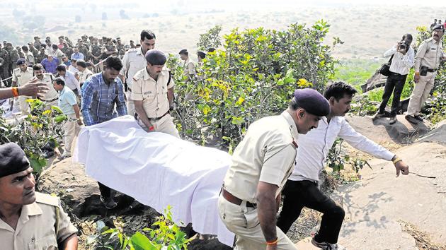 Police personnel carry body of an alleged SIMI operative killed in an encounter on Bhopal outskirts on October 31.(Mujeeb Faruqui/HT Photo)