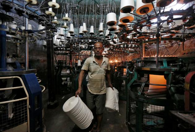 An employee carries cloth rolls inside an undergarment factory in Kolkata. (REUTERS) An employee carries cloth rolls inside an undergarment factory in Kolkata. (REUTERS)