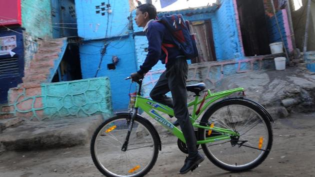 A boy leaves for school on his bicycle at a slum colony. Meanwhile, on February 6th, 350 slum dwellers who had lived for decades at the slums at Nehru Camp in east Delhi’s Patparganj were allotted flats in Sector 16B in Dwarka, which is many miles away. (Burhaan Kinu/HT PHOTO) A boy leaves for school on his bicycle at a slum colony. Meanwhile, on February 6th, 350 slum dwellers who had lived for decades at the slums at Nehru Camp in east Delhi’s Patparganj were allotted flats in Sector 16B in Dwarka, which is many miles away. (Burhaan Kinu/HT PHOTO)