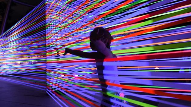 A child is seen through the light-art installation by Katarzyna Malejka & Joachim Stugocki of Poland titled ‘Horizontol Interference’. (ROSLAN RAHMAN / AFP)
