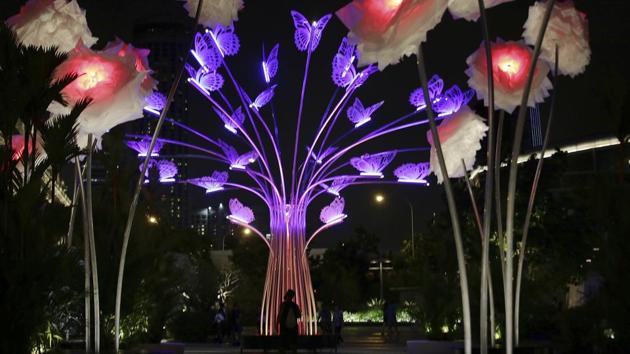 A man is silhouetted against an illuminated light sculpture titled ‘The Colorful Garden of Light’ by TILT of France. (Wong Maye-E / AP)