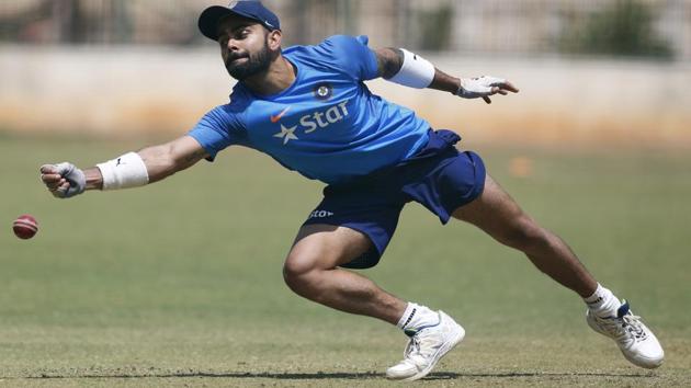 India's captain Virat Kohli stretches to catch the ball during a training session ahead of their second cricket test match against Australia. (AP) India's captain Virat Kohli stretches to catch the ball during a training session ahead of their second cricket test match against Australia. (AP)