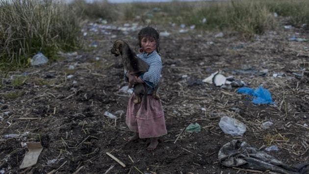 Melinda Quispe walks on the trash strewn shore of Lake Titicaca, as she holds her dog, in her village Kapi Cruz Grande of Peru. The governments of Peru and Bolivia signed a pact in January to spend more than $500 million to attack the pollution problem of Lake Titicaca, though the details were vague. (Rodrigo Abd/AP) Melinda Quispe walks on the trash strewn shore of Lake Titicaca, as she holds her dog, in her village Kapi Cruz Grande of Peru. The governments of Peru and Bolivia signed a pact in January to spend more than $500 million to attack the pollution problem of Lake Titicaca, though the details were vague. (Rodrigo Abd/AP)