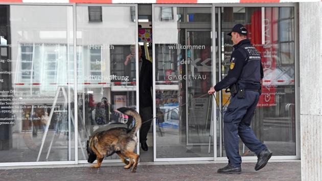 A policeman with a sniffer dog in Gaggenau, southwestern Germany, which received a bomb threat after blocking a rally by Turkey's justice minister.(AFP)
