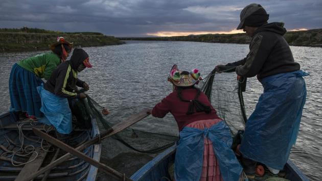 The Avila family fishes on the Coata River. (Rodrigo Abd/AP) The Avila family fishes on the Coata River. (Rodrigo Abd/AP)