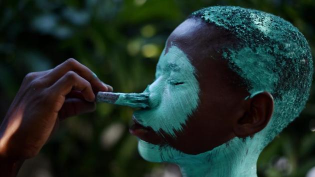 A reveler is painted during preparations for the second day of the 2017 National Carnival Parade . (HECTOR RETAMAL / AFP) A reveler is painted during preparations for the second day of the 2017 National Carnival Parade . (HECTOR RETAMAL / AFP)