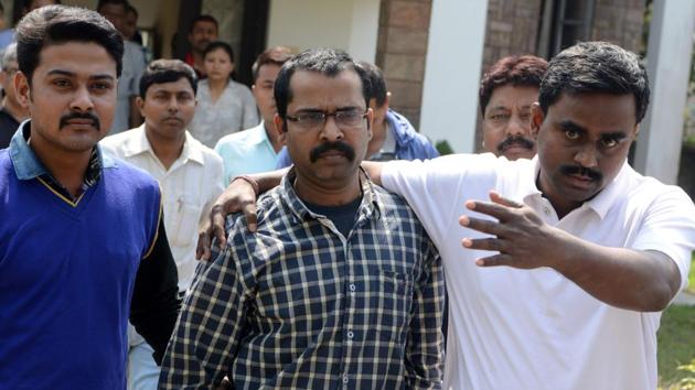 CID officials escort child welfare officer Debasish Chanda (centre) for an appearance at a court in Jalpaiguri on Saturday. (AFP) CID officials escort child welfare officer Debasish Chanda (centre) for an appearance at a court in Jalpaiguri on Saturday. (AFP)