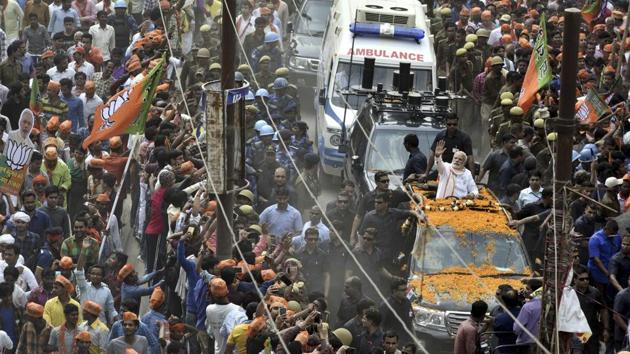 Prime Minister Narendra Modi greets the crowd at a road show in Varanasi . (Arun Sharma/HT PHOTO)