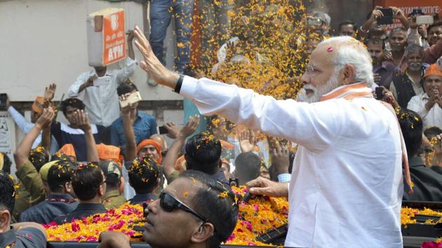 Prime Minister Narendra Modi showered with flower petals during the roadshow. (Adarsh Gupta / HT Photo)