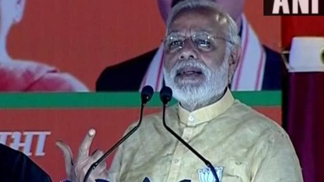 Prime Minister Narendra Modi waves to people during his road show in Varanasi on Sunday.(ANI)