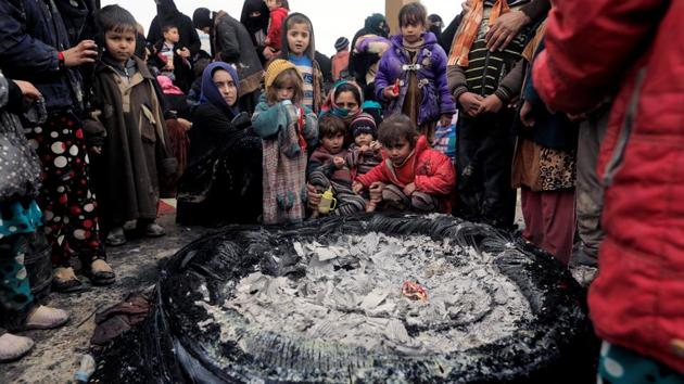Displaced Iraqis warm themselves after walking under rain while fleeing their homes. (Zohra Bensemra/REUTERS) Displaced Iraqis warm themselves after walking under rain while fleeing their homes. (Zohra Bensemra/REUTERS)