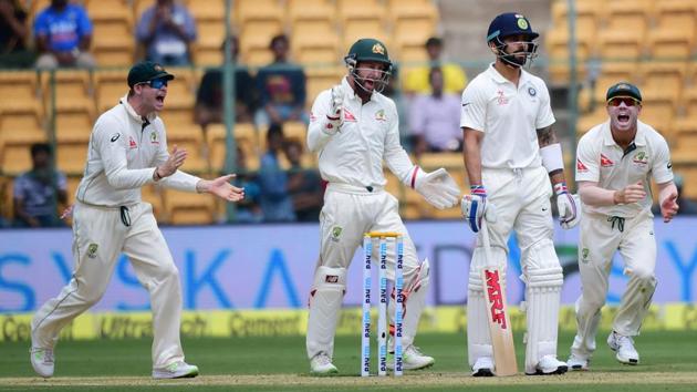 India cricket team skipper Virat Kohli looks on as Australian cricketers celebrate his dismissal.(PTI)