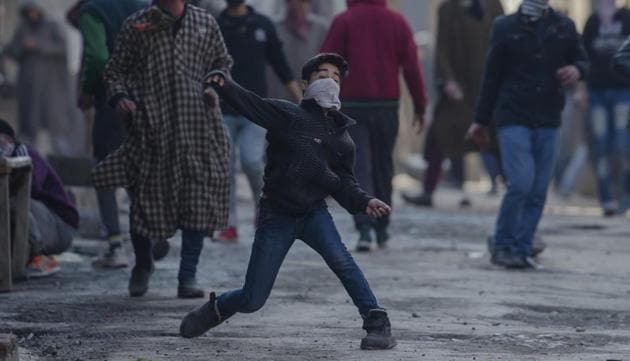 A masked Kashmiri youth throws stones at Indian security forces during a protest in Srinagar,.(AP Photo)