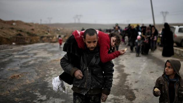 An Iraqi man carries a girl as they walk down a road to flee Mosul. (Aris Messinis/AFP) An Iraqi man carries a girl as they walk down a road to flee Mosul. (Aris Messinis/AFP)