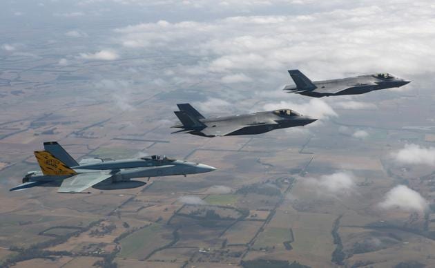 The Royal Australian Air Forces first F-35A Lightening II aircraft, 01 and 02 (C&R) flying in formation with No 2 Operational Conversion Unit F/A-18A Hornet (L) in transit to the Australian International Airshow at Avalon airport in Victoria. (Craig BARRETT / AFP) The Royal Australian Air Forces first F-35A Lightening II aircraft, 01 and 02 (C&R) flying in formation with No 2 Operational Conversion Unit F/A-18A Hornet (L) in transit to the Australian International Airshow at Avalon airport in Victoria. (Craig BARRETT / AFP)
