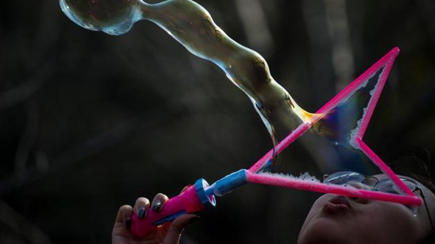 A girl makes a rainbow bubble next to a cherry blossom tree in the Gucun Park in Shanghai. (Johannes EISELE / AFP) A girl makes a rainbow bubble next to a cherry blossom tree in the Gucun Park in Shanghai. (Johannes EISELE / AFP)