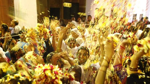 Hindu widows throw flower petals at each other as part of Holi celebrations organized by a NGO at Meera Sahbhagini Ashram in Vrindavan. (AJAY AGGARWAL/HT PHOTO)
