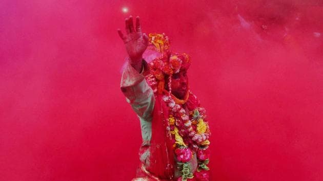A devotee takes part in rituals on Laddu Holi at Radha Rani temple in Barsana, Uttar Pradesh on Sunday. (PTI)