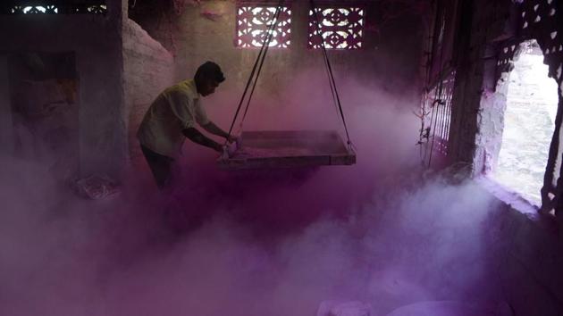A labourer makes Gulal inside a factory at Fulbari village on the outskirts of Siliguri. (AFP)