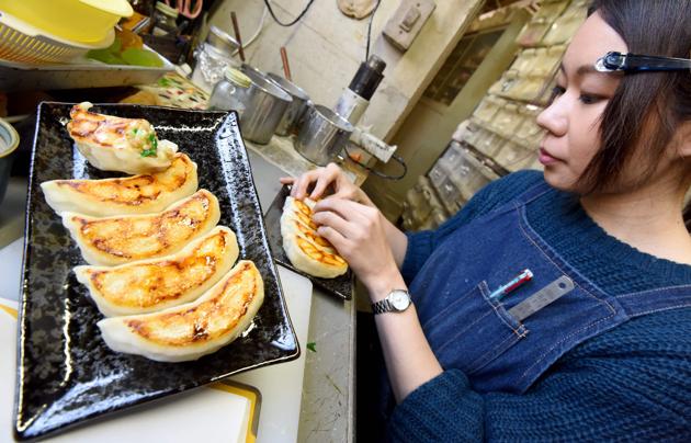 A craftswoman of Fake Food Hatanaka making plastic replicas of "gyoza" dumplings at the company's studio in Tokorozawa. (TORU YAMANAKA / AFP) A craftswoman of Fake Food Hatanaka making plastic replicas of "gyoza" dumplings at the company's studio in Tokorozawa. (TORU YAMANAKA / AFP)