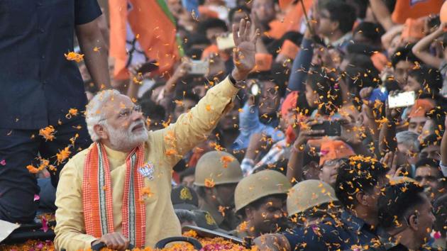Prime Minister Narendra Modi waves to people during his roadshow in Varanasi on Sunday.(PTI Photo)