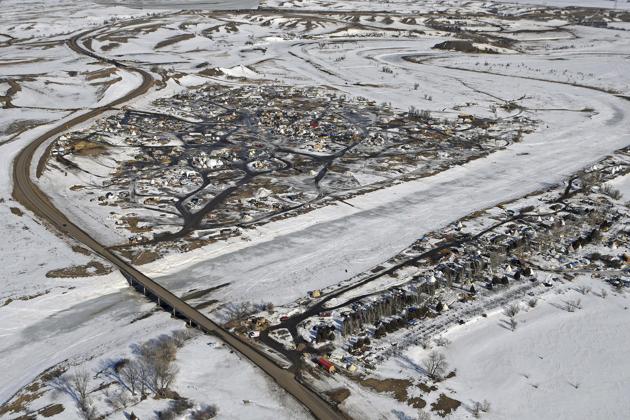 This aerial photo shows North Dakota Highway 1806, at left, where it crosses Cannonball River and Dakota Access pipeline protest camps on both sides of the river Monday, Feb. 13, 2017, in Cannon Ball, N.D. A federal judge on Monday refused to stop construction on the last stretch of the Dakota Access pipeline, which is progressing much faster than expected. It's the last big section of the $3.8 billion pipeline, which would carry oil from North Dakota to Illinois.(AP)