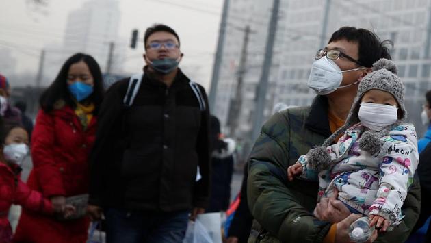 People, including kids, wear face masks as they cross a street on a polluted day in Beijing on January 4. (REUTERS) People, including kids, wear face masks as they cross a street on a polluted day in Beijing on January 4. (REUTERS)