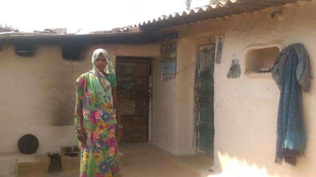 Homemaker Divya Devi outside her house–her solar panel visible on the roof–in Sonbhadra district, Uttar Pradesh (UP). Devi, like many others who live below poverty line in UP, was first promised a free electricity connection in 2005. Six months ago, Devi bought a small solar unit, which now powers two bulbs, enough for her four children to read past 6 pm and study harder.(Mukta Patil/IndiaSpend)