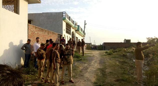 Policemen gather near a building where a suspected militant was holed up in Lucknow on Tuesday.(Deepak Gupta/HT Photo)