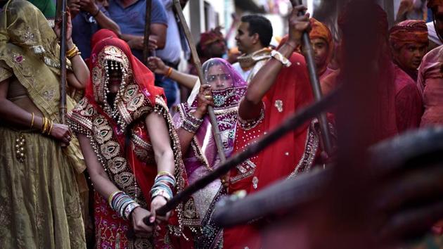 Women of Barsana dressed up in traditional attires beat the men of Nandagaon during the festival. (Ajay Aggarwal/HT PHOTO)