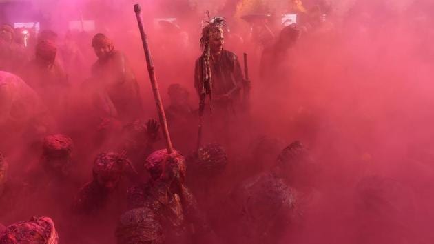 Indian villagers smear themselves with colours during the Lathmar Holi festival at the Nandji Temple in Nandgaon, some 120 kms from New Delhi. The women of Nandgaon, the home town of Hindu God Krishna, attack the men from Barsana, the legendary home town of Radha, consort of Hindu God Krishna, with wooden sticks in response to their efforts to put color on them, reciprocating acts performed yesterday in Barsana between the women of that village with the men of Nandgaon as they observe the Lathmar Holi festival. (Ajay Aggarwal/HT PHOTO)