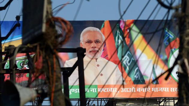 A BJP election campaign hoarding displaying an image of Prime Minister Narendra Modi ahead of voting in Uttar Pradesh assembly elections in Varanasi.(AFP File Photo)