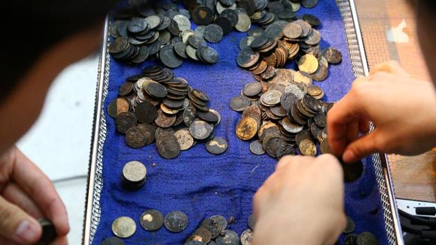 Officers count coins that were removed from the stomach of Omsin, a 25 year old femal green sea turtle. (Athit Perawongmetha / REUTERS)