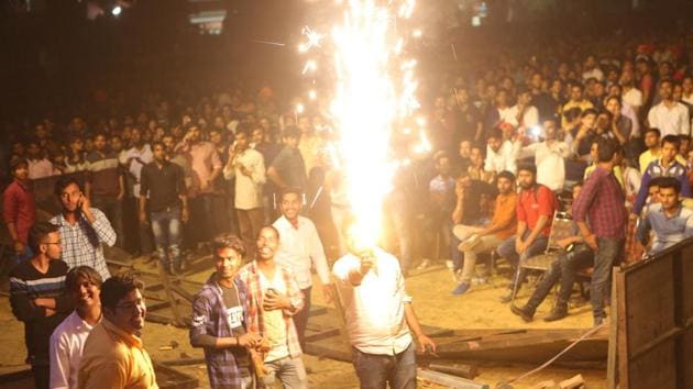 A student at the venue holds a firework in his hand. Many students were seen pushing each other and causing disruption in the concert. (Manoj Verma/HT Photo) 