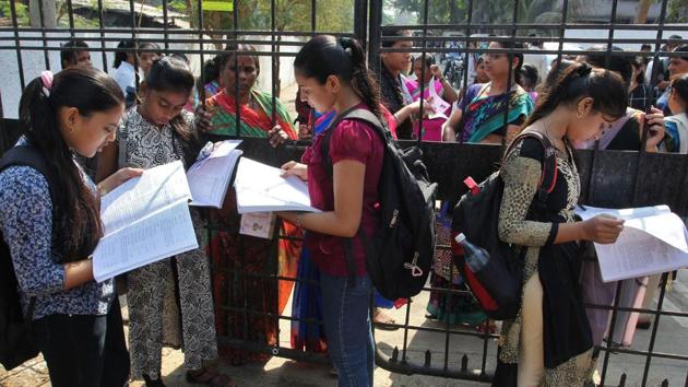 Secondary School Certificate students do last-minute revisions outside an exam centre in Thane. (Praful Gangurde/HT Photo)