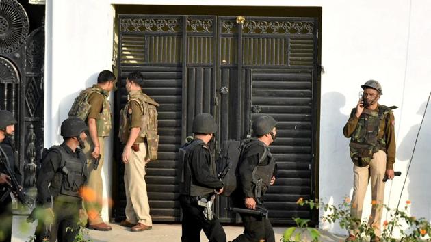 Uttar Pradesh anti-terror squad members take position near a building where the suspected terrorist was holed up in Thakurganj area of Lucknow on Tuesday. (PTI Photo)