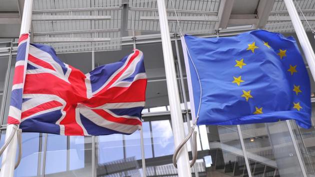 The British Union flag (left) and the European Union flag (right) fly in London on March 2, 2017.(AFP)