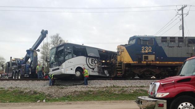 Men prepare to move a charter bus after a freight train crashed into the bus in Biloxi, Mississippi, on March 7.(AP Photo)