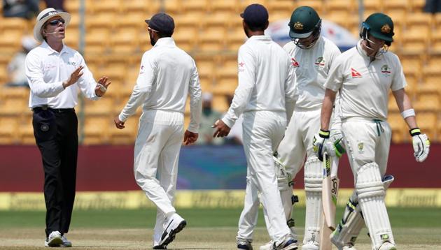 Virat Kohli (2nd L) speaks to the umpire as Steve Smith (R) walks off the ground after being dismissed on day 4 of second India vs Australia Test.(REUTERS)