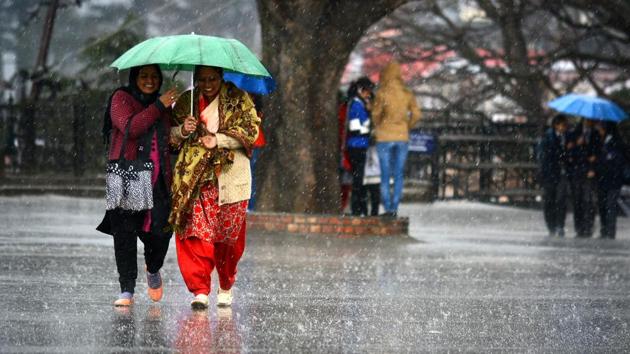 Women walk during rain at Ridge area in Shimla, Himachal Pradesh in February.(HT FILE PHOTO)