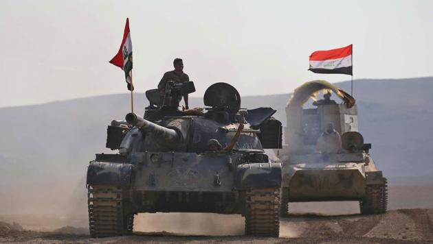 Iraqi government forces supported by fighters from the Abbas Brigade, which fight under the umbrella of the Shia popular mobilisation units, advance in village of Badush some 15 kilometres northwest of Mosul during the ongoing battle to retake the city's west from Islamic State (IS) group jihadists on March 7, 2017.(AFP Photo)