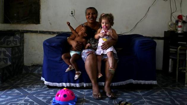 Lina Maria da Silva, 62, a babysitter, poses for a photograph with the children she takes care of at her home in the Cantagalo slum in Rio de Janeiro, Brazil. (Pilar Olivares / REUTERS)