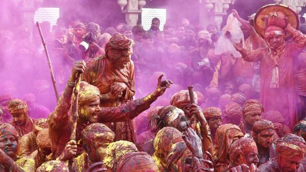 Indian villagers smear themselves with colour during the Lathmar Holi festival in Nandgaon, around 120 kms from New Delhi. The women of Nandgaon chase the men from Barsana, the legendary hometown of Radha, consort of Hindu God Krishna, with wooden sticks in response to the latter’s efforts to put colour on them.(Ajay Aggarwal/HT Photo)
