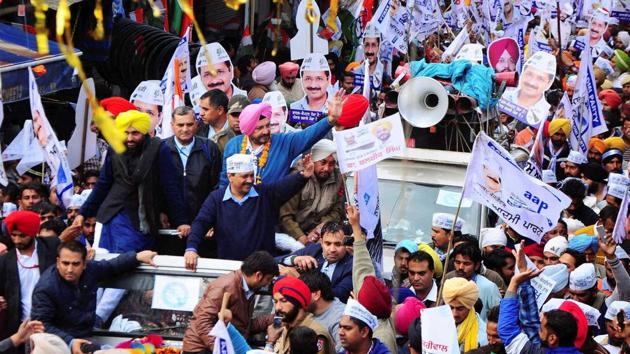 Arvind Kejriwal with party MP Bhagwant Mann and AAP MLA candidate in Patiala, Balbir Singh wave to their supporters during a road show in Patiala. (PTI)