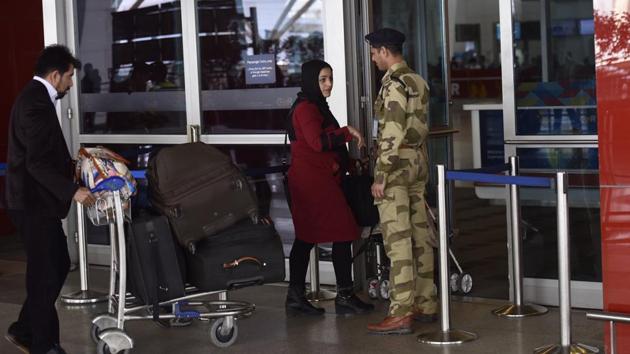 A CISF security personnel checks a passenger at the IGI airport in New Delhi.(HT Photo)