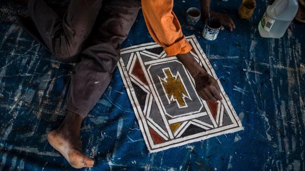 A student of South African artist Esther Mahlangu, 81, paints a design in her home in Mabhoko Village, Siyabuswa, Mpumalanga.   (GULSHAN KHAN / AFP) 