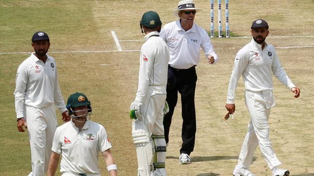 India's captain Virat Kohli (right) speaks to the umpire as Australia's captain Steven Smith (2nd L) walks off the ground after being dismissed.(REUTERS) India's captain Virat Kohli (right) speaks to the umpire as Australia's captain Steven Smith (2nd L) walks off the ground after being dismissed.(REUTERS)
