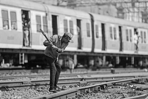 A track maintainer hammers the bolts on a fishplate along a track at the Chhatrapati Shivaji Terminus in Mumbai.